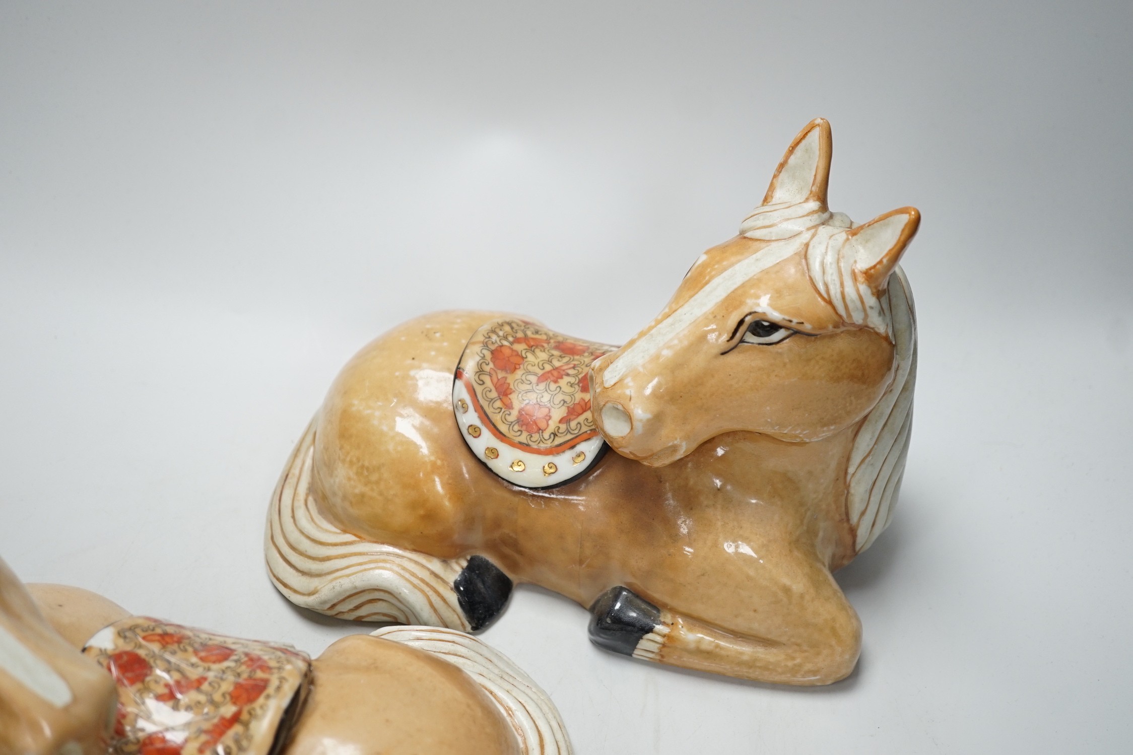 A pair of Chinese ceramic seated horses, 18cm high